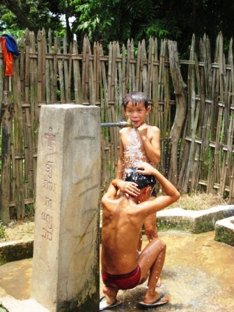 Kinder waschen sich an der Wasserentnahmestelle des vom Roten Kreuzes errichteten Wassersystems