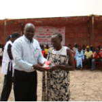 A female participant receiving gift from SRCS Bentiu branch Director after having given the correct answer to a question related to water related diseases.